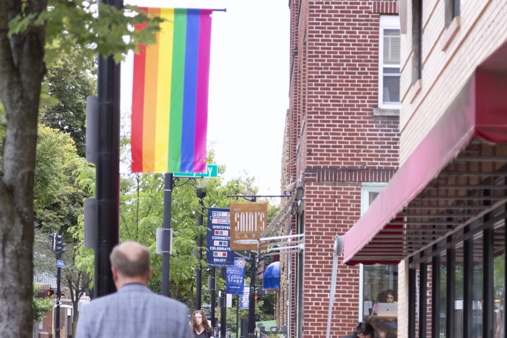 Photo of city street with rainbow Pride flag on display