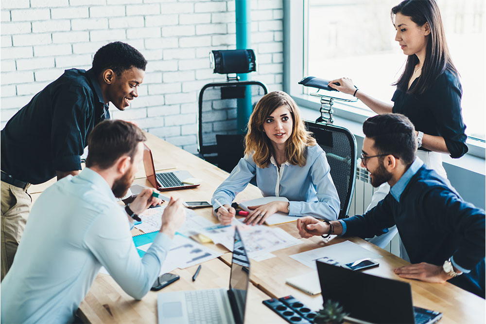 diverse team of male and female business professionals collaborating at table