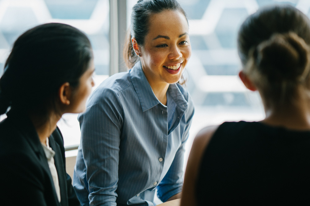 young woman business manager talking with her team in her office