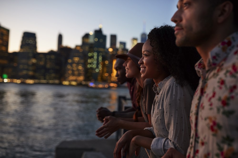 Image of folks looking out onto the water amidst a city skyline