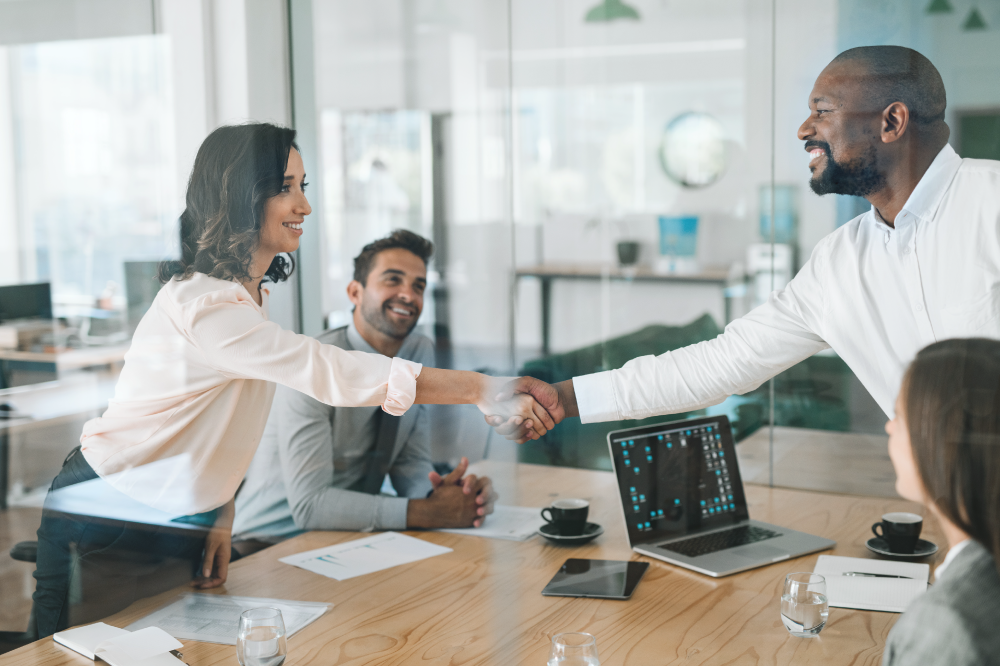 smiling diverse businesspeople shaking hands together during a meeting