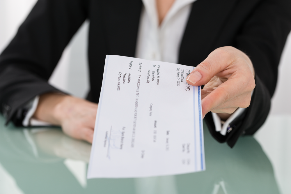 businesswoman holding out paycheck