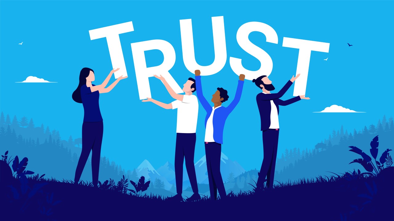 Image of people holding up letters spelling "trust"