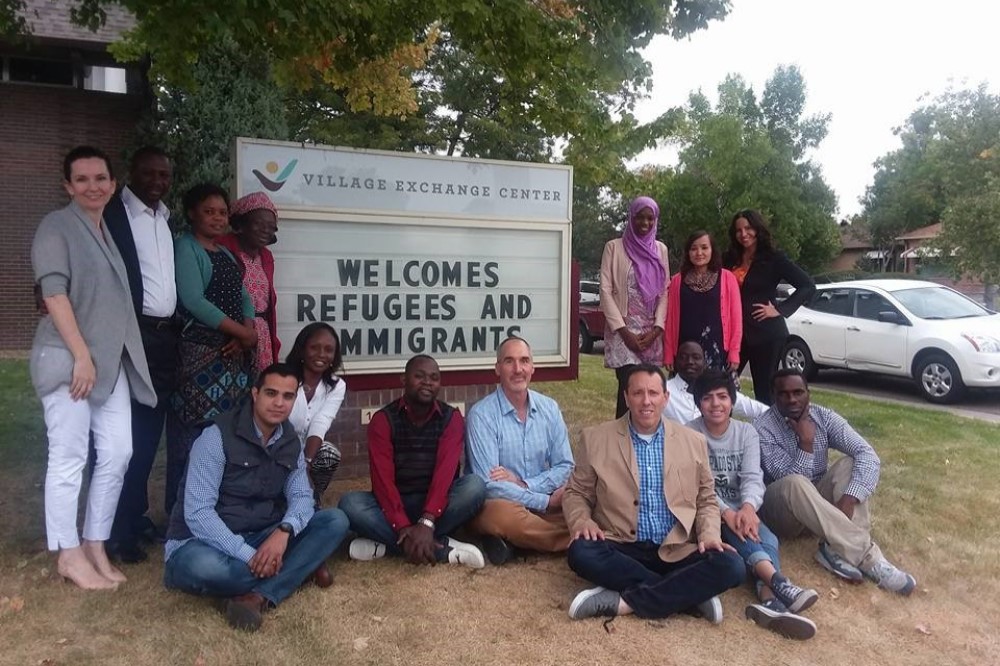 People standing around sign that reads immigrants welcome