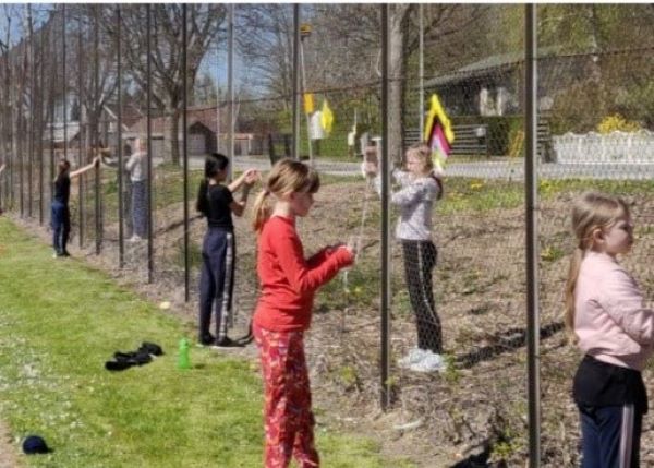children doing art on a fence