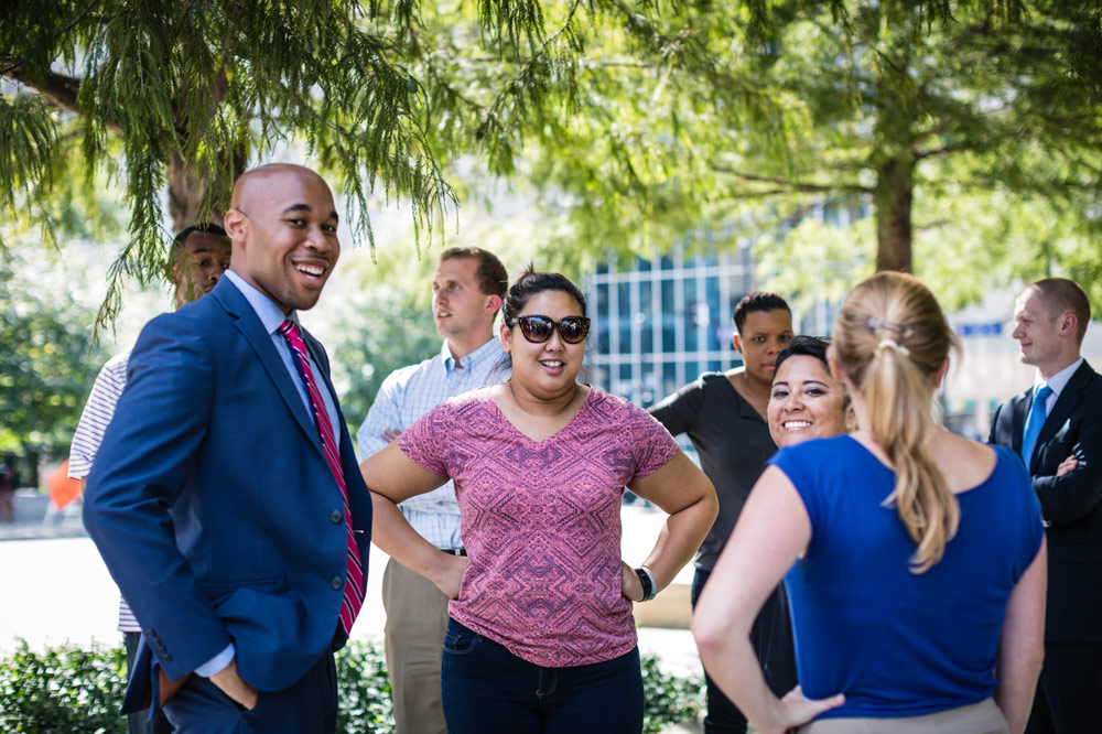 diverse group of young businessmen and businesswomen talking outside