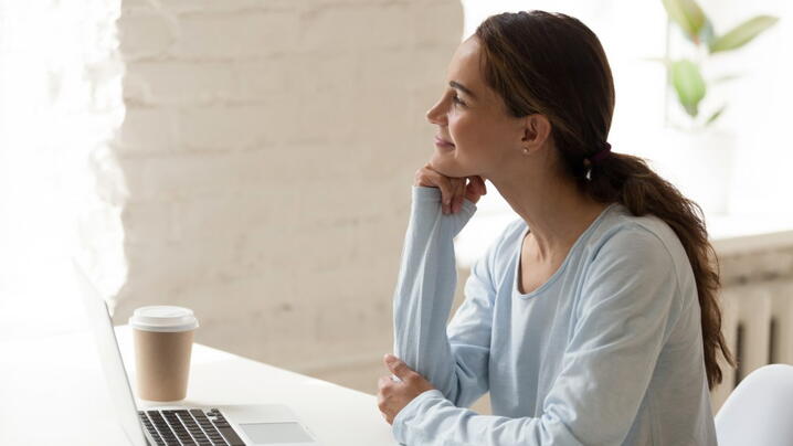 Photo of woman working from home, smiling to herself