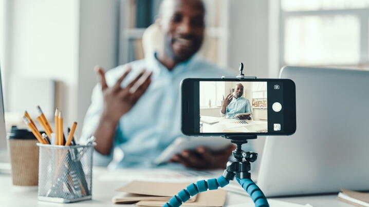 Photo of man filming a video on his smartphone
