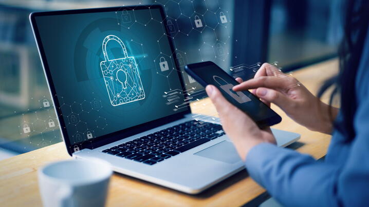 digital lock on smartphone in women's hand and laptop screen for cybersecurity protection