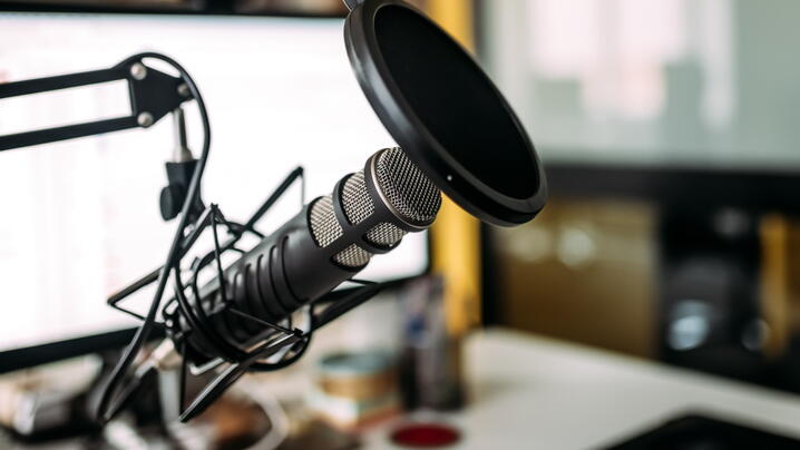 podcast studio with computer and microphone with pop filter