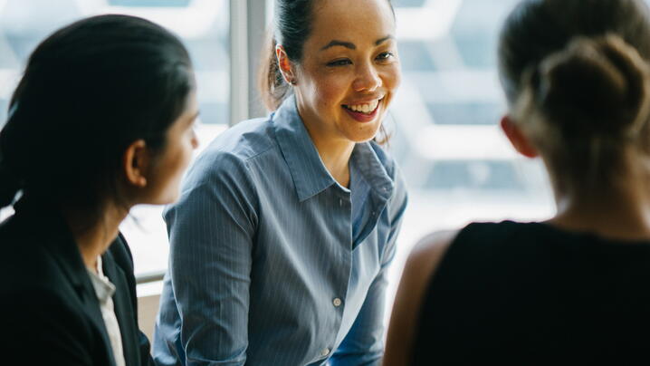 young woman business manager talking with her team in her office