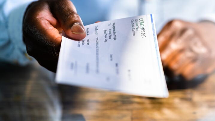 Image of a person handing out a paycheck