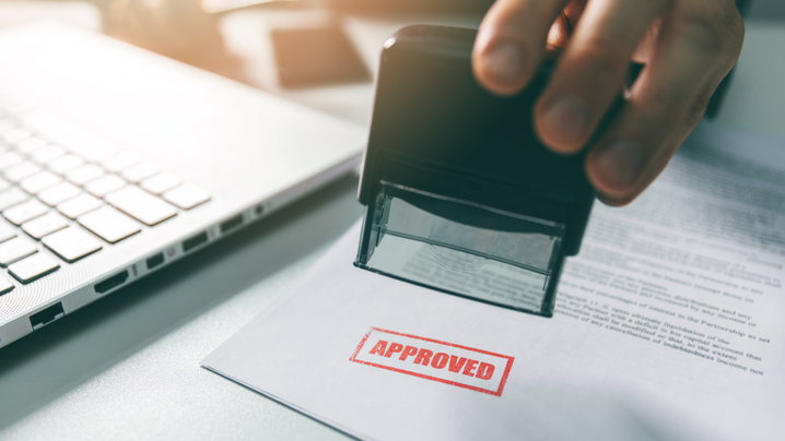 approved stamp - businessman stamping document in office