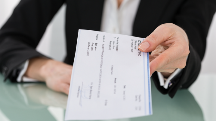 businesswoman holding out paycheck