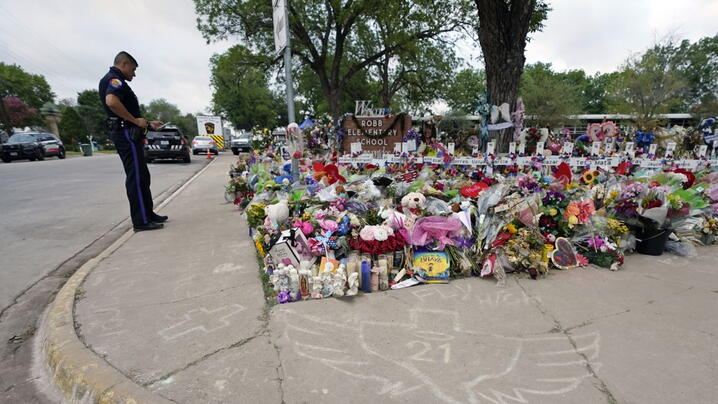 A police officer visits a memorial at Robb Elementary School in Uvalde, Texas, created to honor the victims killed in the 2022 school shooting.