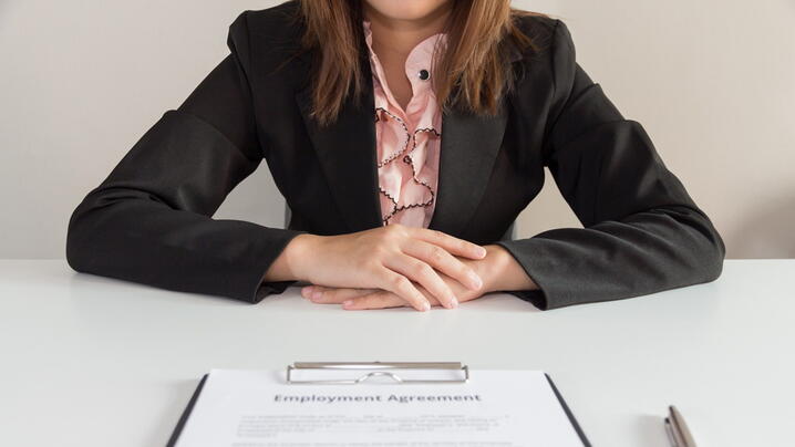 Image of person with employment agreement in front of them