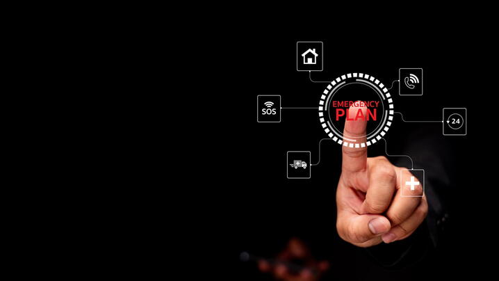 Image of finger pushing an emergency communications plan button