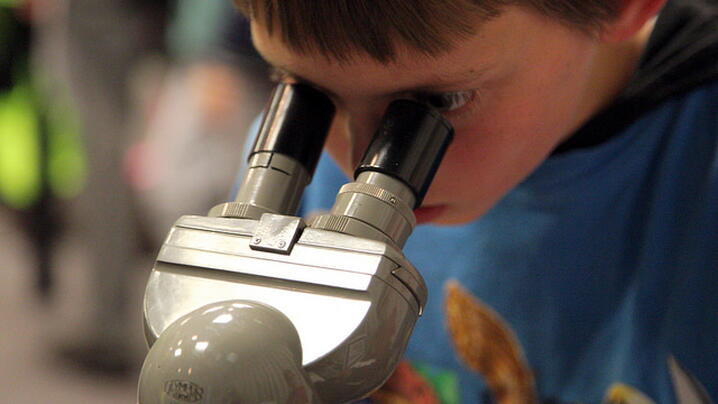 image of a child looking through a microscope