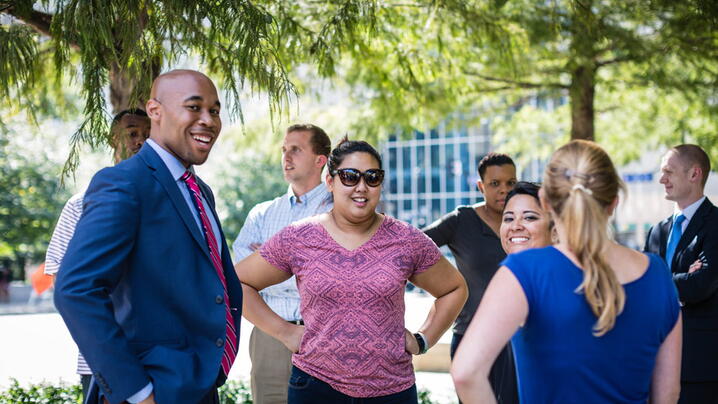 diverse group of young businessmen and businesswomen talking outside