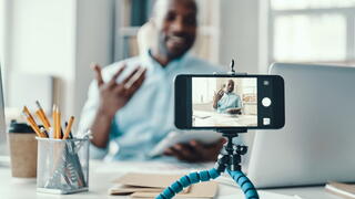 Photo of man filming a video on his smartphone