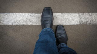 Image of a person crossing a line on pavement