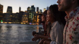 Image of folks looking out onto the water amidst a city skyline