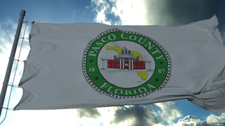 flag with official seal of pasco county florida in sunshine
