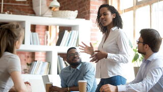 Image of person speaking to others at conference table