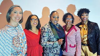 Five strong women, smiling after speaking on a panel