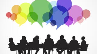 People talking around table with colored speech bubbles