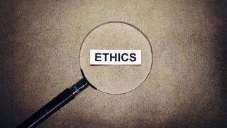 Magnifying glass over the word 'ethics'