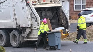 Image of author assisting refuse crew