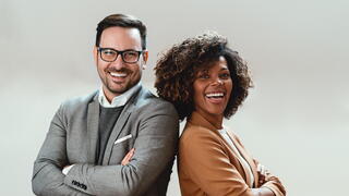 Image of two people with arms crossed and smiling